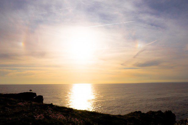 Ceci est une photo du soleil au dessus de la mer pris de la terre.