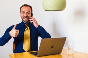 Jeremias téléphone tout en levant un pouce en l'air. Polytache.