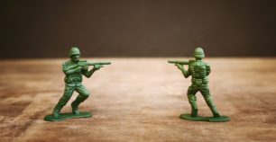 Deux soldats miniatures pointent des fusils l'un sur l'autre