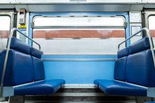 Un carré de quatre places vides dans une rame de métro bleue en mouvement